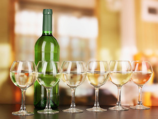 White wine in glass and bottle on room background