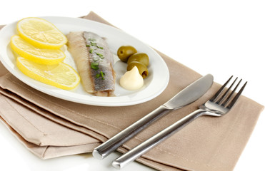 Dish of herring and lemon on plate isolated on white