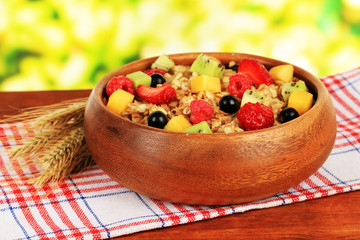 Oatmeal with fruits on table on bright background