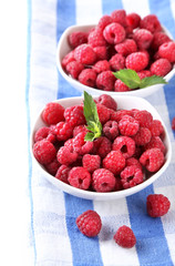 Ripe sweet raspberries in bowls, isolated on white