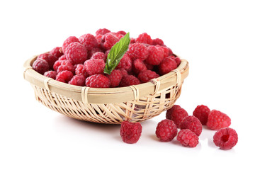 Ripe sweet raspberries in basket, isolated on white