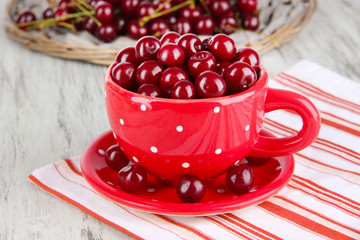 Sweet cherry in cup on table close-up