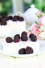Cheesecake with fresh berries on white plate on wooden table