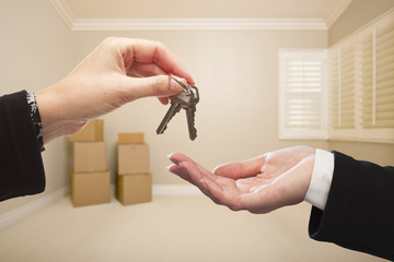 Woman Handing Over the House Keys Inside Empty Tan Room
