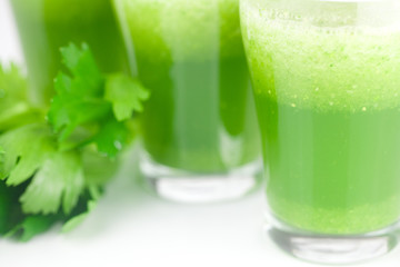 celery and three glasses with celery juice isolated on white
