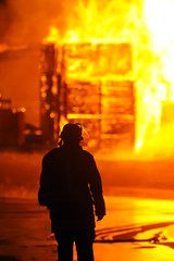 Fototapeta premium Feuerwehrmann vor Flammenhölle