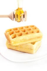 Fototapeta na wymiar Belgian waffles on a plate, stick for honey and honey isolated o