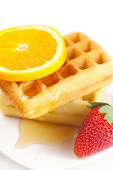 Belgian waffles,honey,orange and strawberries on a plate isolate
