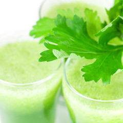 celery and three glasses with celery juice isolated on white