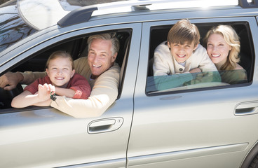 Girl Showing Car Keys While Sitting With Family In Car