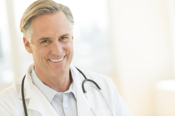 Doctor With Stethoscope Around Neck Smiling In Hospital