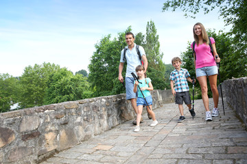 Fototapeta premium Family on a rambling journey crossing roman bridge