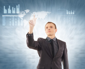 A young businessman in formal clothes pointing on a display