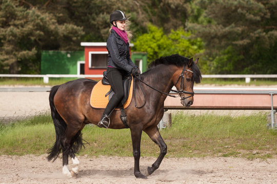 Mädchen reitet auf ihrem Pferd