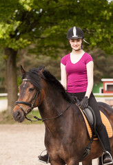 Obraz premium Mädchen sitzt auf ihrem Pony