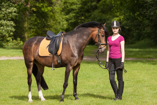 Mädchen steht neben ihrem Pferd