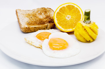 Breakfast with fried eggs, toasts, Orange and pineapple.