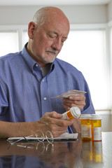 Older man with prescription medications, vertical