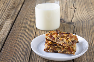 Granola bars with nuts and dried fruits, glass of milk
