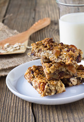 Granola bars with nuts and dried fruits, glass of milk
