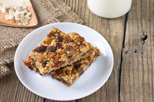 Granola bars with nuts and dried fruits, glass of milk