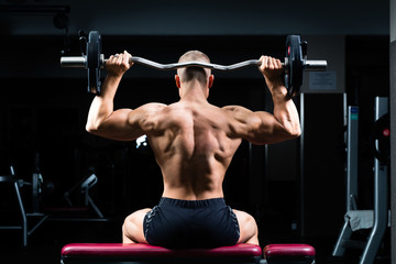Fototapeta na wymiar Man in gym or fitness studio on weight bench