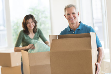 Fototapeta na wymiar Couple With Cardboard Boxes In New House
