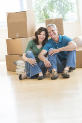 Fototapeta na wymiar Mature Couple Sitting Together On Floor In New House