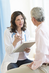 Doctor Discussing With Patient In Clinic