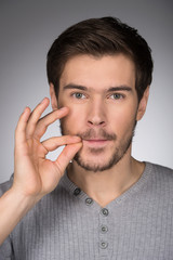 No more word. Portrait of young men showing a silent sign by his