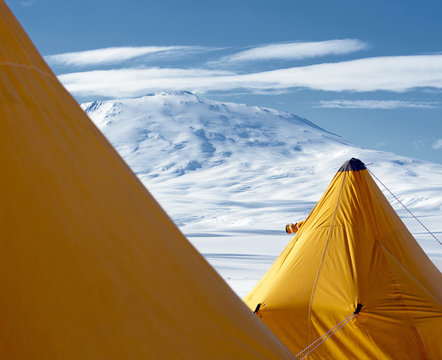 Antarctic landscape with yellow tents in the foreground