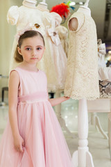 Beautiful girl in a pink dress in modern store