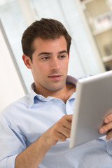 Man using tablet pc on couch at home