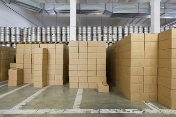 Large warehouse with beer kegs and boxes in stock brewery