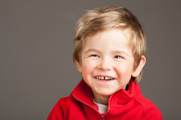 Portrait of laughing blonde toddler boy on white