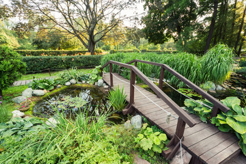 A beautiful green park with trees, flowers and a pond