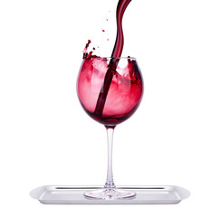 glass with red wine splash on a tray