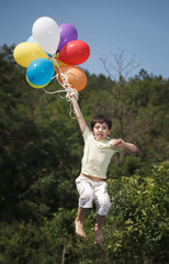 beautiful young man in a spring field with lots of balloons