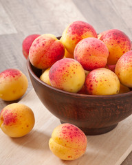 bowl of fresh apricots on wooden table