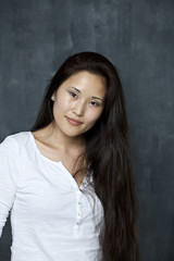 Fototapeta premium Asian young woman standing by wall