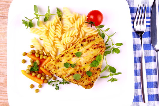 Grilled poultry steak with fusilli peas, carrots and oregano