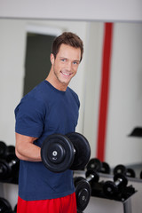 Fototapeta na wymiar lächelnder mann trainiert im fitnessstudio