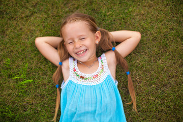 Beautiful girl lying on the grass and laughs