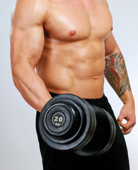 Fototapeta na wymiar Handsome muscular man working out with dumbbells