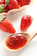 Homemade jam with strawberry on background