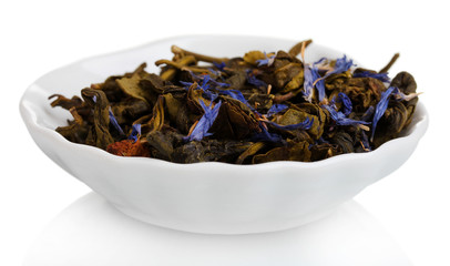 Green dry tea leaves in plate isolated on white