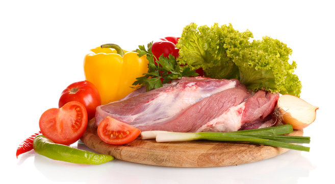 Raw meat and vegetables on a wooden board isolated on whitе