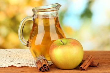 Full jug of apple juice and apple