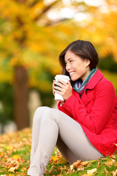 Autumn woman drinking coffee in fall forest