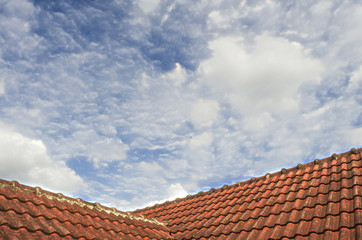 Naklejka premium Tiled Roof with Fluffy Cloud Blue Sky 105